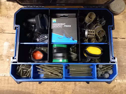 Recensent toont een open HARDCASE FEEDER SYSTEM, georganiseerd met korven, methods en klein materiaal.