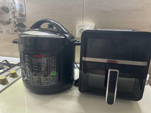 Recenzie de la client: Air Fryer-ul Novio StonePro negru pe un blat de bucătărie, lângă un alt aparat de gătit.