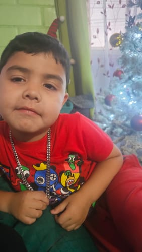 Cliente muestra a un niño usando la Cadena Cuban Link 8mm para probar su buena calidad.