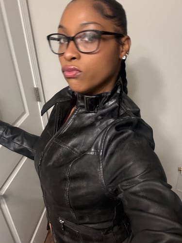 Customer in a close-up wearing the black leather Villain Moto jacket, highlighting its fitted cut and collar clasp.