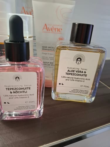 Reviewer's Regenerating Serum and Hydrating Toner bottles on a bathroom shelf.