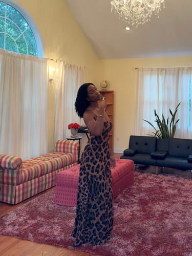 Reviewer standing in a living room, showing a side view of the Naked Print A-Line Maxi Dress.