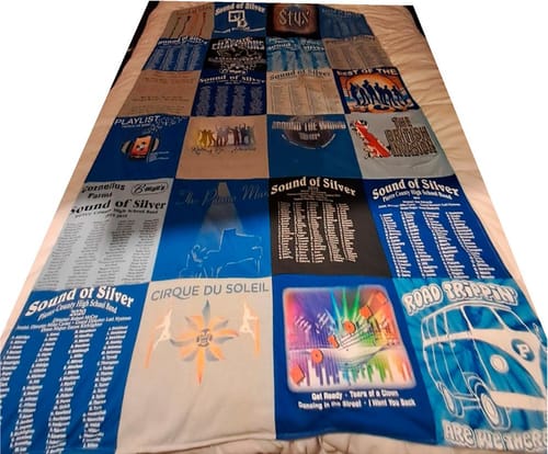Reviewer's finished Premium T Shirt Quilt with marching band shirts laid out flat on a bed.