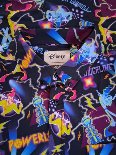 Close-up of a customer's Disney Powerline shirt, showing the vibrant, detailed character pattern and the collar tag.