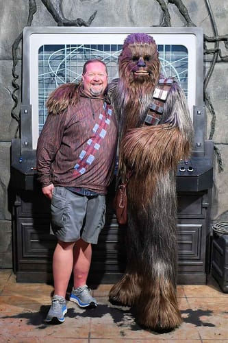 Reviewer wearing 'The Chewie' Performance Hoodie while posing next to the character Chewbacca.