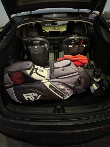 Customer's two folded Cybercarts and one golf bag shown fitting in the trunk of a car.