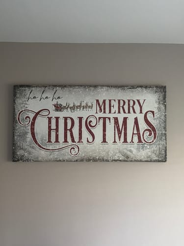 Customer's rustic 'Ho Ho Ho Merry Christmas Wall Sign' with red lettering, displayed on a neutral wall.