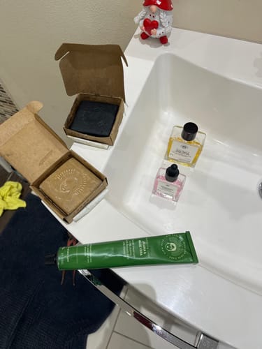 Customer's Balance Routine skincare products, including soaps and serums, arranged on a white bathroom sink.