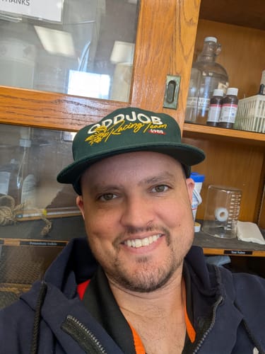Reviewer smiling in a close-up, wearing the green Big Structured A-Frame Hat.
