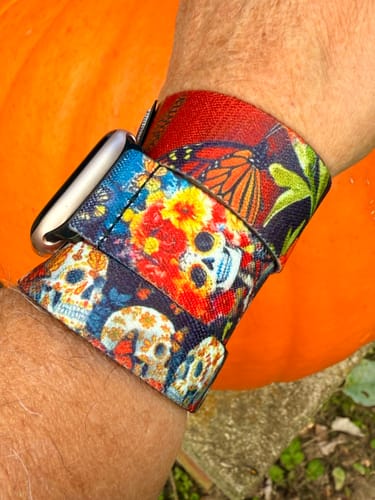 Close-up of a reviewer wearing the colorful Live Vibrantly Watch Band with a custom monarch butterfly strap.