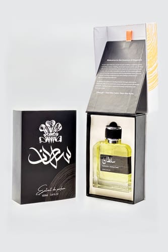 Customer's Sultan perfume bottle with yellow liquid, displayed inside its open black box next to the outer packaging.