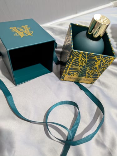 Customer's Tabac Soleil perfume bottle displayed in its elegant teal box with gold accents and a matching ribbon.