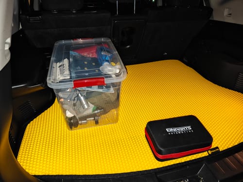 Recenzent pokazuje swoją jaskrawożółtą matę do bagażnika, idealnie dopasowaną do wnętrza samochodu.