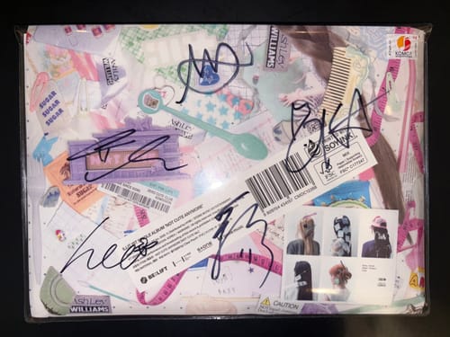 Customer's hand-autographed ILLIT 'NOT CUTE ANYMORE' promo album in a clear protective sleeve.