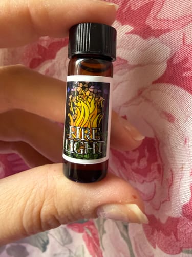 Customer holding the small amber bottle of Firelight oil.