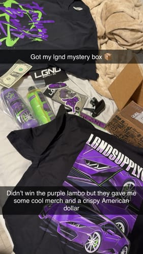 Customer's unboxing of the LGND83 Mystery Box showing two graphic tees, stickers, cleaning products, and a dollar bill.