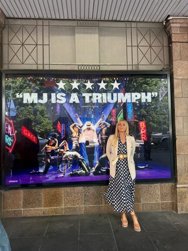 Customer wearing the navy and white polka dot Fallon Shirt Dress, styled with a blazer and wedges for a night out.