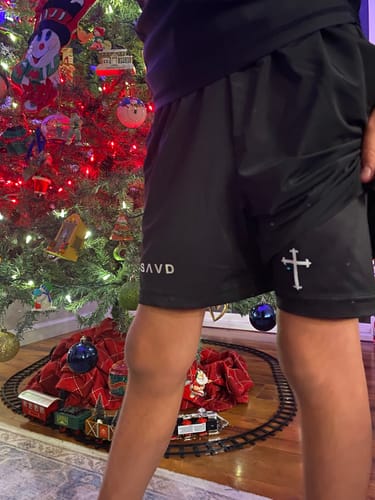Customer wearing the black SAVD 'Minimal Cross' Youth Performance Shorts, showing the fit and logos.