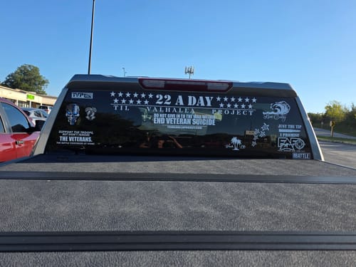 Reviewer's truck back window displaying multiple stickers from their T.V.P. Elite Membership in support of veterans.