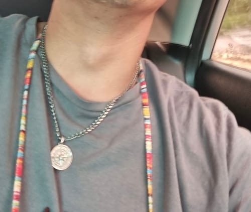 Un cliente lleva puesto el Colgante de Compass con una camiseta gris.