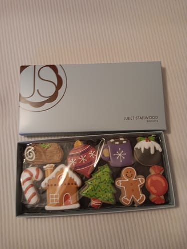 Customer's open Festive Favourites Deluxe Biscuit Box showing nine decorated Christmas biscuits neatly arranged inside.