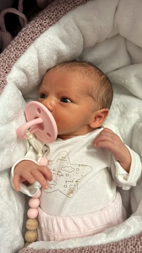 Bebé recién nacida de una clienta usando el suave chupete clásico Nenina & Co rosa.