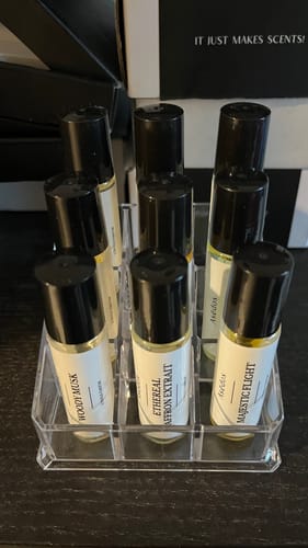 Reviewer's collection of several roll-on perfume oils, including the Mandarin Wood, in a clear organizer.