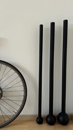Reviewer's three black maces of different sizes standing upright against a wall.