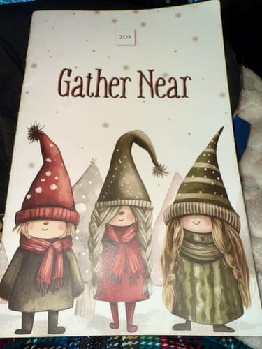Customer's November 2025 Booklet showing the cover with three illustrated gnomes and the words 'Gather Near'.