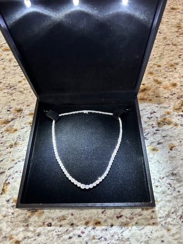 Customer showing the 7 Carats Diamond Necklace inside its lighted black presentation box.