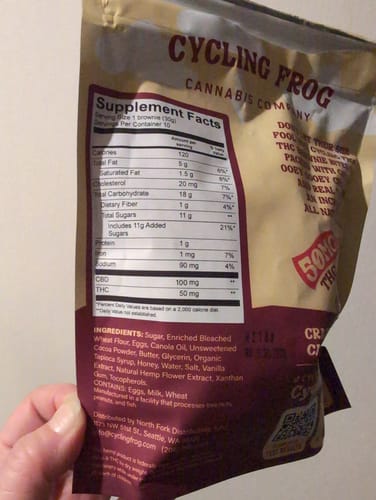 Customer holding the Chocolate Brownie Bites pouch, showing the supplement facts and ingredients list on the back.