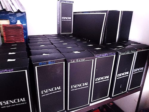El cliente muestra su colección de perfumes ESENCIAL en sus cajas negras, incluido el H028.