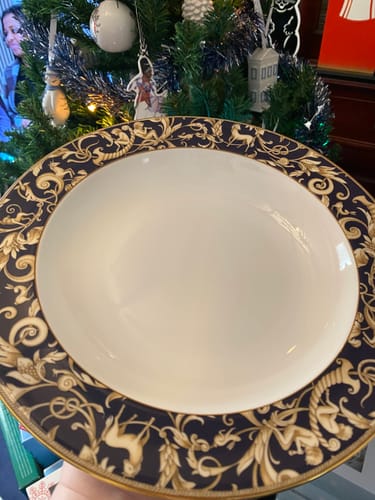 Customer holding a Wedgwood Cornucopia Pasta Bowl with a decorative blue and gold rim.