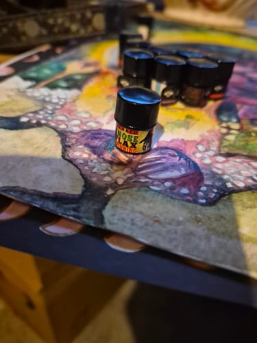 Customer's small black Perchta scent jar on a colorful surface with other jars in the background.