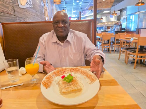 Reviewer sitting at a restaurant table in an image submitted for Bubba Kush Smalls (Oz)