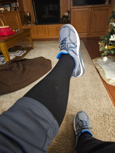 Customer wearing black Performance Eucalyptus Compression Socks with sneakers in their living room.