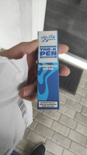 Customer holding the blue and white box for the ROLLZ THCA Vape pen, showing the Amnesia Haze strain.