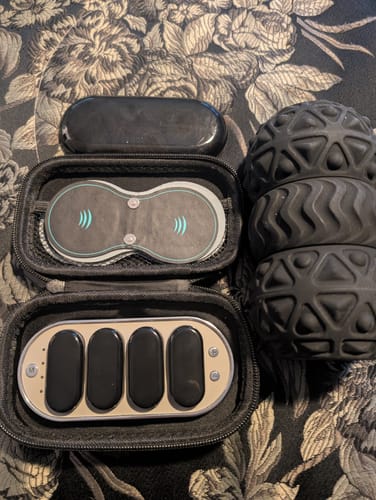 Customer's Vibit TENS device and components inside its open black travel case.