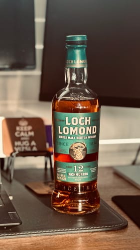 Customer's bottle of Loch Lomond Inchmurrin 12 Year Old whisky standing on a desk.