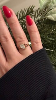 Customer wearing the Leesha Birthstone Ring, showing its two dainty pear-cut stones on a gold band.