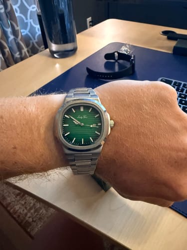 Reviewer wearing their Lucky Fours® Laurent watch, showing its green textured face and silver-colored band on their wrist.