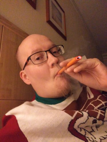 Reviewer holding the orange ROLLZ THCA Vape to their mouth, showing its glowing tip.