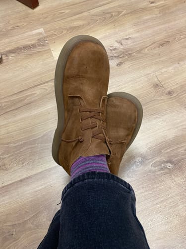Reviewer wearing a brown vintage leather ankle boot with striped socks, seen from a top-down angle.