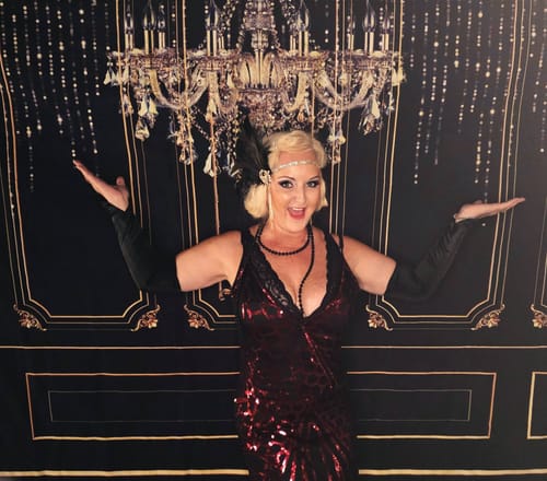 Customer in a red sequin dress and costume posing for the 1920s Murder Mystery Game.