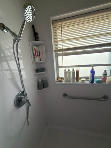 Customer's chrome 1-Spray Handheld Shower Head Set installed in a white shower stall.