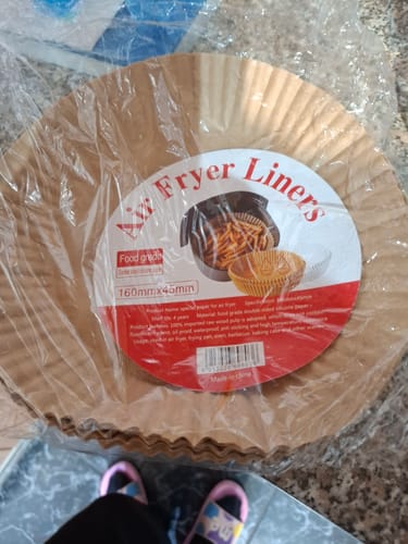 Recenzentul arată pachetul cu 100 de hârtii de copt, încă sigilat în plastic.