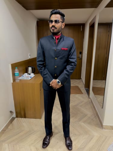 Reviewer wearing the Satan Sapphire Blue Rimless Sunglasses with a formal dark suit indoors.