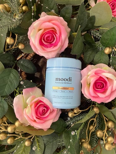 Customer's blue tub of Gingerbread blend displayed in a decorative wreath with pink roses and greenery.