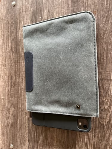 Customer's grey canvas Magic Keyboard Durable Sleeve holding an iPad on a wooden surface.