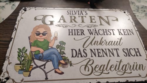 Rezensent zeigt das personalisierte Gartenschild 'Silvia's Garten' mit einer Cartoon-Frau und einem lustigen Spruch.